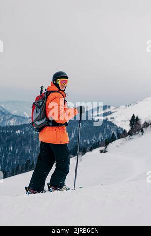 Skifahrer mit Skistock, der auf Schnee läuft Stockfoto