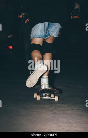 Frau Skateboarding im Park in der Nacht Stockfoto