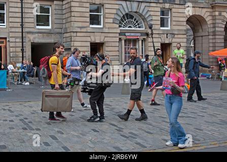 Dreharbeiten auf der Royal Mile, Edinburgh, Schottland, Großbritannien. August 2022. Richard Gadd in Gelb mit Koffer, schottischer Schriftsteller, Schauspieler und Komiker, umgeben von Filmcrew, während er an den Dreharbeiten für Baby Reindeer beteiligt war, ein zukünftiges Netflix-Drama. Kredit: ScottishCreative/Alamy Live News. Stockfoto