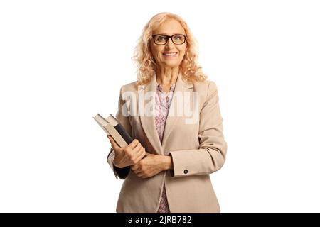 Reife Lehrerin hält Bücher und lächelt isoliert auf weißem Hintergrund Stockfoto