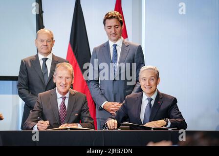 Toronto, Kanada. 23. August 2022. Bundeskanzler Olaf Scholz (l, SPD) und Justin Trudeau (2. von rechts, Premierminister von Kanada, stehen hinter Herbert Diess (2. von links, Vorsitzender des Vorstands der Volkswagen AG, Und François-Philippe Champagne, kanadischer Minister für Innovation, Wissenschaft und Industrie, beim Deutsch-Kanadischen Wirtschaftsforum, als sie eine Absichtserklärung unterzeichnen. Im Mittelpunkt der Reise steht die Zusammenarbeit zwischen den beiden Ländern im Klima- und Energiesektor. Quelle: Kay Nietfeld/dpa/Alamy Live News Stockfoto