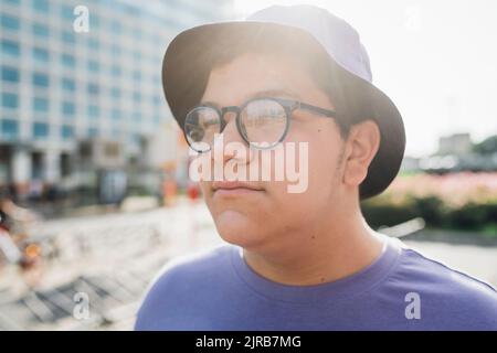 Nachdenklicher Teenager mit Brille an sonnigen Tagen Stockfoto