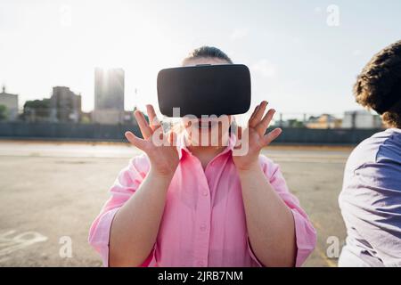 Teenager-Mädchen trägt VR-Brille von Bruder Stockfoto