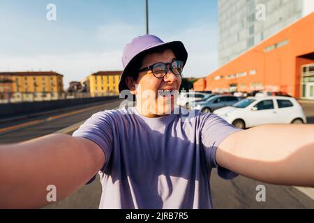 Teenager winken und machen Selfie auf der Straße an einem sonnigen Tag Stockfoto