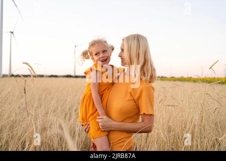 Mutter und Tochter spielen zusammen im Weizenfeld Stockfoto