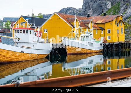 Norwegen, Nordland, Nusfjord, Fischerboote vor Stelzenhäusern an der Küste Stockfoto