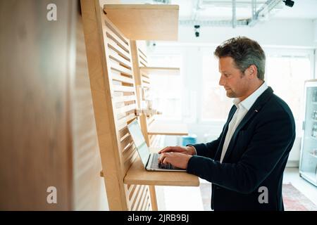 Geschäftsmann mit Laptop im Büro arbeiten Stockfoto