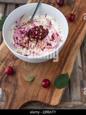 Kohlenhydratarme Frühstückschüssel mit griechischem Joghurt, Sauerkirschkompott und gerösteten Haselnüssen Stockfoto