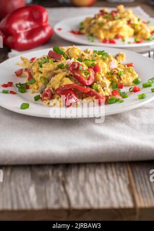 Low Carb Frühstück zu Hause mit Rührei und Gemüse. Zwei Platten auf Holztisch mit Kopierplatz Stockfoto