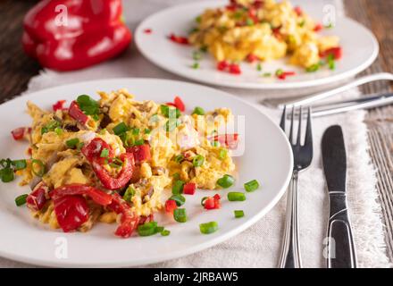 Teller mit Rührei und Gemüse. Hausgemachtes Low Carb oder ketogenes Frühstück auf einem Tisch Stockfoto