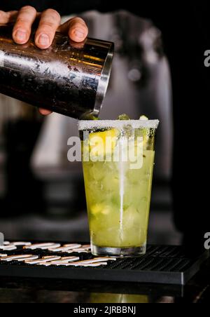 Barkeeper gießt Ananas margarita aus dem Shaker in Salzglas Stockfoto