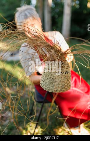 Esparto-Graskorb vor dem Handwerker Stockfoto