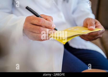 Nahaufnahme des Arztes, der im Impfpass schreibt Stockfoto