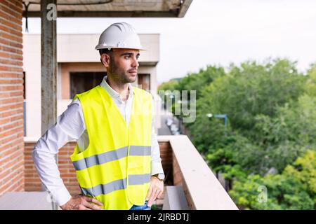 Selbstbewusster, intelligenter Bauingenieur, der auf der Baustelle der Wohnung steht Stockfoto