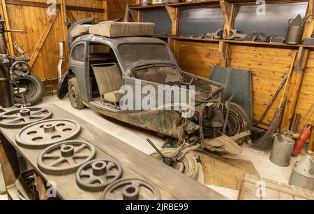 Rostiges Auto in der Garage. Kaputtes altes Auto in der Garage, verlassenes Fahrzeug Stockfoto