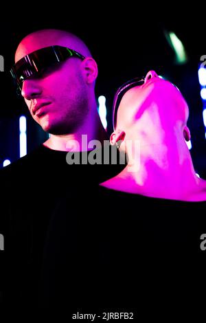 Junge Frau, die mit einer intelligenten Brille von einem Mann aufschaut Stockfoto