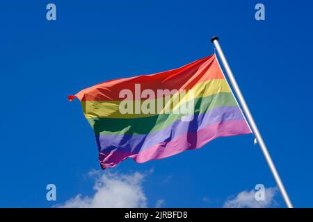 Regenbogenfahne flattert gegen den Himmel Stockfoto