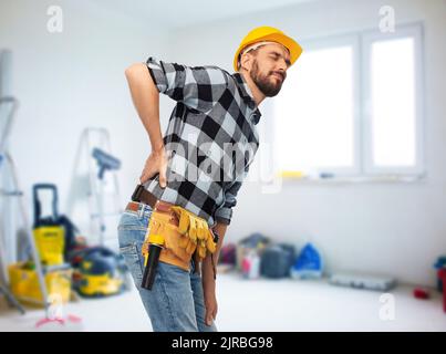 Männlicher Arbeiter oder Baumeister mit Rückenschmerzen Stockfoto