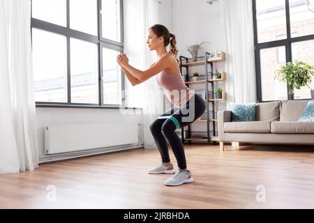 Frau, die zu Hause mit Widerstandsband trainiert Stockfoto