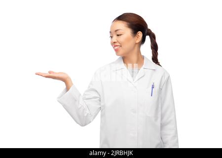 asiatische Ärztin hält etwas auf der Hand Stockfoto