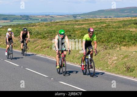 7. August 22 Gower Swansea Wales UK Triathlon Ironman Cycling Event zwei Paar Radfahrer kämpfen auf flachen Strecken durch die Veranstaltung. Stockfoto