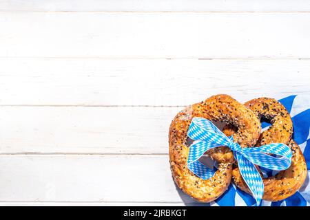 Oktoberfest Urlaub Hintergrund, Menü Mockup. Bavaria Flagge oktoberfest Serviette, Brezel, Bierflasche und Becher auf weißem Holzhintergrund, Kopie s Stockfoto