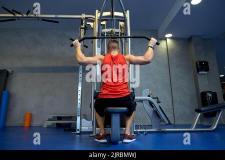 Nahaufnahme eines Mannes, der im Fitnessstudio am Kabelgerät trainiert Stockfoto