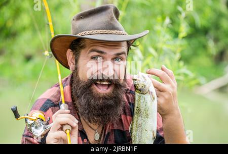 Angeln. Angler mit Angeltrophäe. Fischer und Forelle. Angelhintergründe. Mann hält große Fischforelle in den Händen. Fischer und Trophäe Forelle. Mann Stockfoto