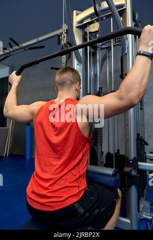 Nahaufnahme eines Mannes, der im Fitnessstudio am Kabelgerät trainiert Stockfoto