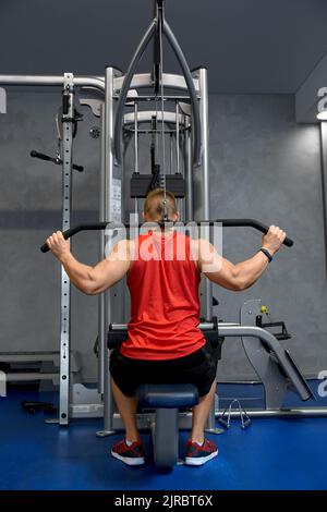Nahaufnahme eines Mannes, der im Fitnessstudio am Kabelgerät trainiert Stockfoto