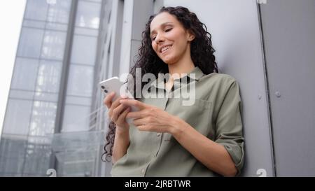 Selbstbewusst 30s Erwachsene Frau Erfolg Geschäftsfrau lächelnd SMS in mobile App mit Telefon Online-E-Commerce-Service im Internet-Chat mit Stockfoto