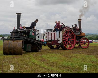 Antriebsmotor, der eine Dampfwalze aus dem Schlamm bei der Launceston Steam & Vintage Rally, Cornwall, Großbritannien, schleppt Stockfoto