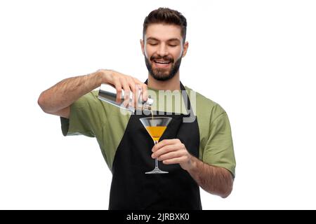 Glücklicher Barkeeper mit Shaker und Glas, der das Getränk zubereitete Stockfoto