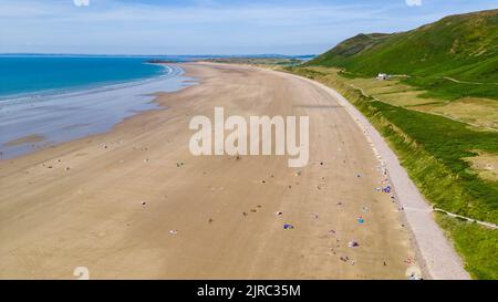 Luftaufnahme von Touristen an einem riesigen, breiten Sandstrand an der Küste von Wales (Rhossili, Gower, Wales) Stockfoto