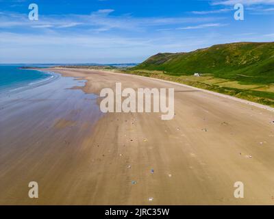 Luftaufnahme von Touristen an einem riesigen, breiten Sandstrand an der Küste von Wales (Rhossili, Gower, Wales) Stockfoto