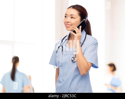 asiatische Krankenschwester ruft auf Smartphone im Krankenhaus Stockfoto