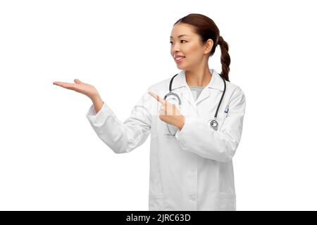 asiatische Ärztin hält etwas auf der Hand Stockfoto