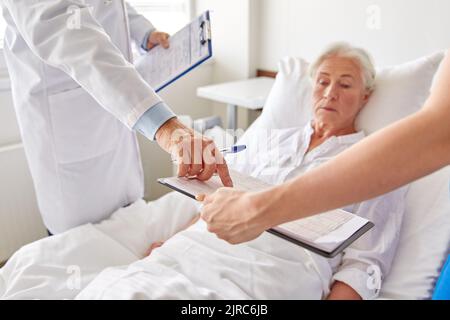 Ältere Frau und Ärzte im Krankenhaus Stockfoto