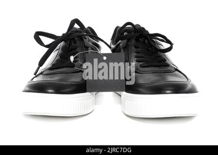 Schwarze Herrenstiefel mit weißer Sohle auf weißem Hintergrund. Schuhe isolieren mit Preisschild für Beschriftung Stockfoto