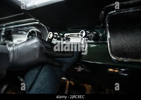 Auto Detaillierung Studioarbeiter reinigt das Innere eines Oldtimer Stockfoto