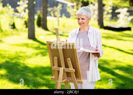 Ältere Frau mit Staffelmalerei im Freien Stockfoto
