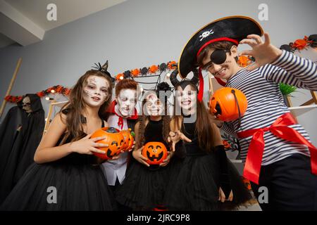 Gruppe von Kinderfreunden in Karnevalskostümen und mit gruseligen Make-up auf der Halloween-Feier. Stockfoto