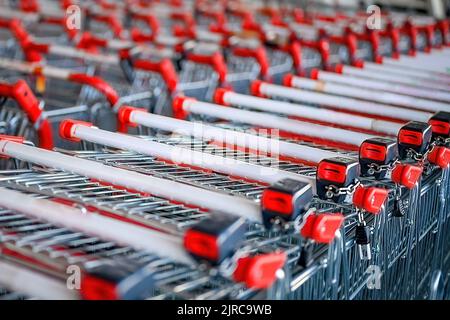 Die Einkaufswagen für Lebensmittel stapelten sich. Viele leere Wagen im Supermarkt. Stockfoto