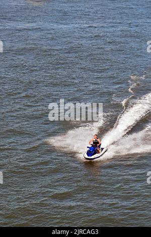 Rotterdam, Niederlande - 2022. August: Luftaufnahme einer Person, die auf dem Nieuwe Maas Fluss, der durch die Stadt fließt, einen schnellen Jetski fährt Stockfoto