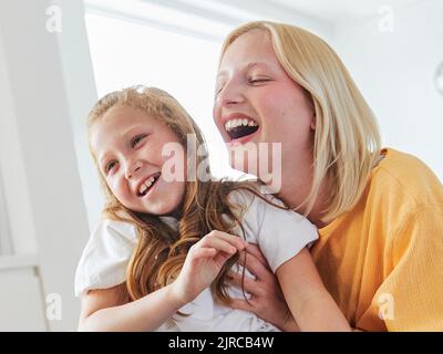 Kind Schwester Spaß Familie Mädchen zusammen Kindheit weiblich glücklich Tochter jung Lifestyle Zuhause indoor Glück Kind Zweisamkeit Mutter Frau Stockfoto