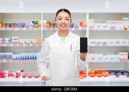 asiatischer Apotheker mit Smartphone in der Apotheke Stockfoto