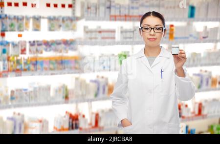 asiatische Apothekerin mit Medizin in der Apotheke Stockfoto