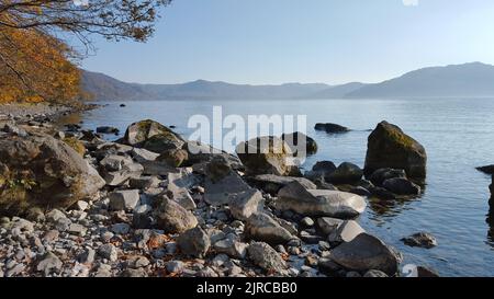 Blick auf die herbstliche Küste vom vulkanischen Lake Towada Stockfoto