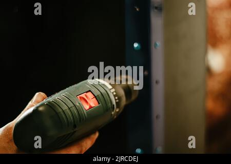 Schraubendreher mit Außenhand. Arbeiter verwendet Bauwerkzeug für die Arbeit. Selektiver Fokus. Stockfoto