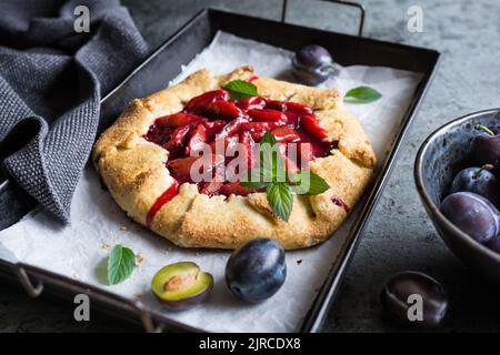 Traditionelle saftige französische Galette-Torte, gefüllt mit Pflaumen Stockfoto